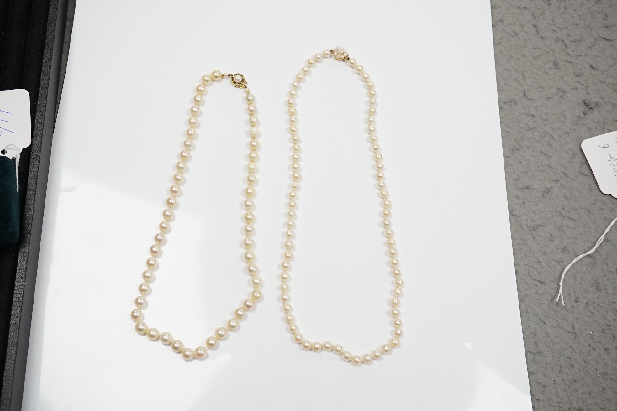 Two modern single strand cultured pearl necklaces, one with cultured pearl and gem set 18ct gold clasp, 48cm, the other with cultured pearl cluster set 9ct gold clasp, 54cm. Condition - fair to good.